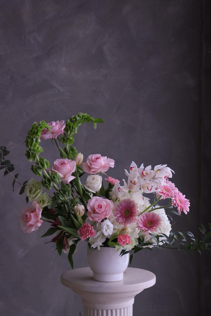 Bouquet of pink and white flowers in a white pot