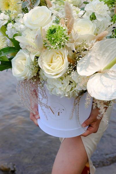 Luxurious floral arrangement with white roses, lilies, and hydrangeas in a tall white box by Ottawa florist.