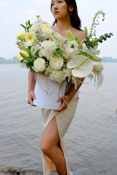  Elegant floral arrangement featuring white roses, lilies, and hydrangeas in a tall white box from an Ottawa florist.