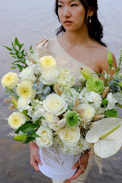 Luxurious floral arrangement with white roses, lilies, and hydrangeas in a tall white box by Ottawa florist.