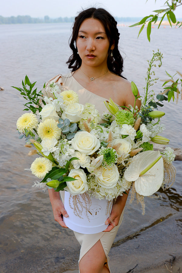  Elegant floral arrangement featuring white roses, lilies, and hydrangeas in a tall white box from an Ottawa florist.