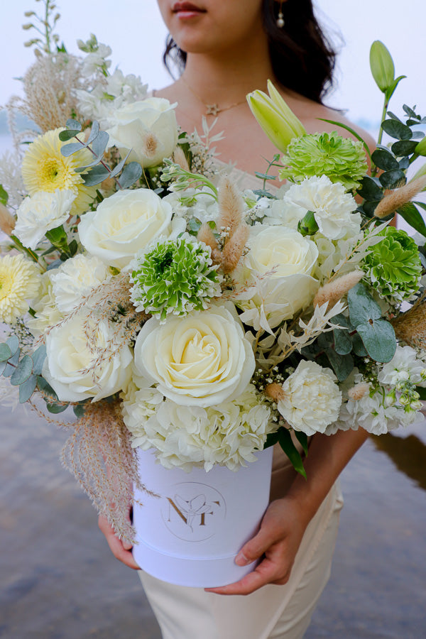 Luxurious floral arrangement with white roses, lilies, and hydrangeas in a tall white box by Ottawa florist.