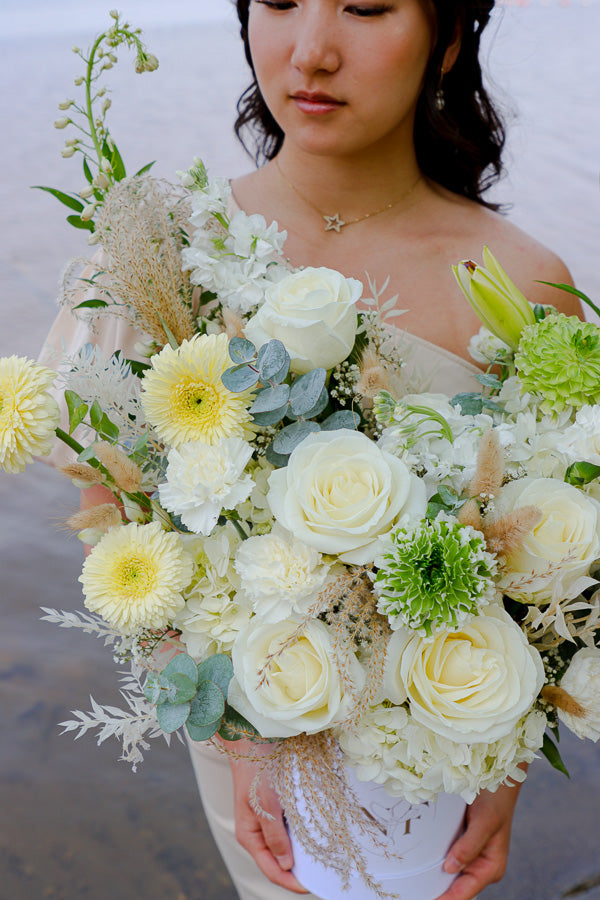  Elegant floral arrangement featuring white roses, lilies, and hydrangeas in a tall white box from an Ottawa florist.