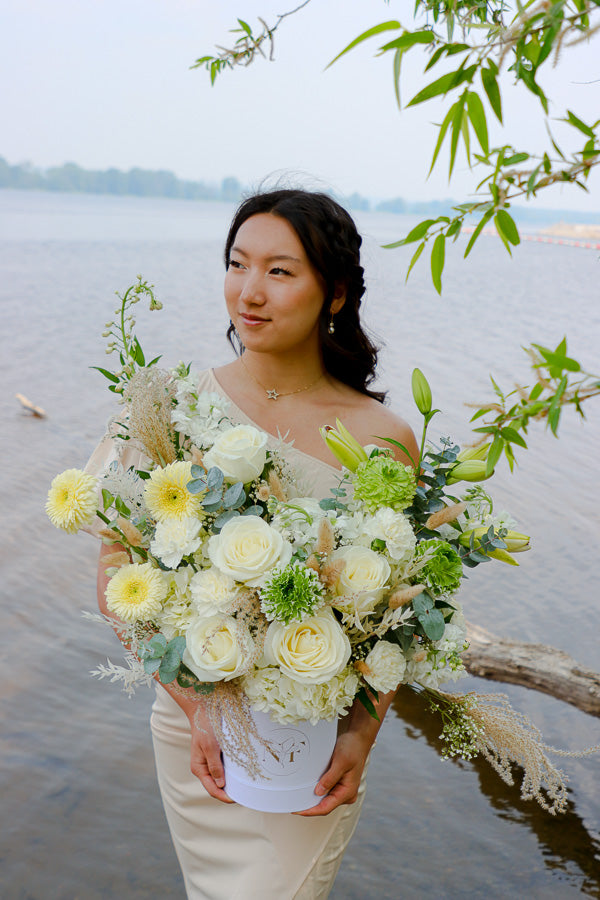  Elegant floral arrangement featuring white roses, lilies, and hydrangeas in a tall white box from an Ottawa florist.