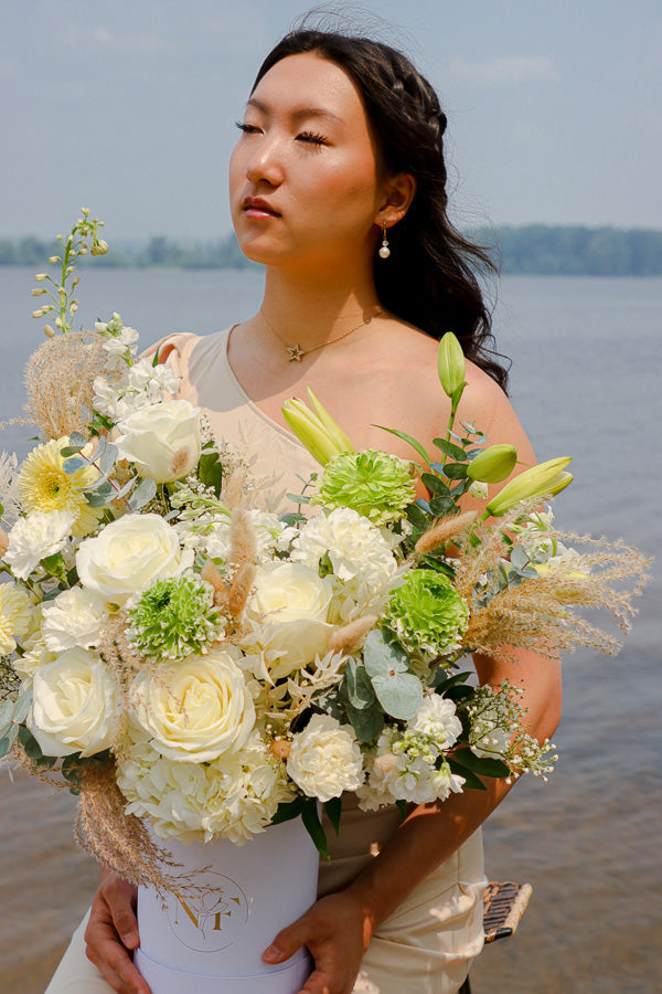  Elegant floral arrangement featuring white roses, lilies, and hydrangeas in a tall white box from an Ottawa florist.