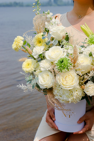  Elegant floral arrangement featuring white roses, lilies, and hydrangeas in a tall white box from an Ottawa florist.