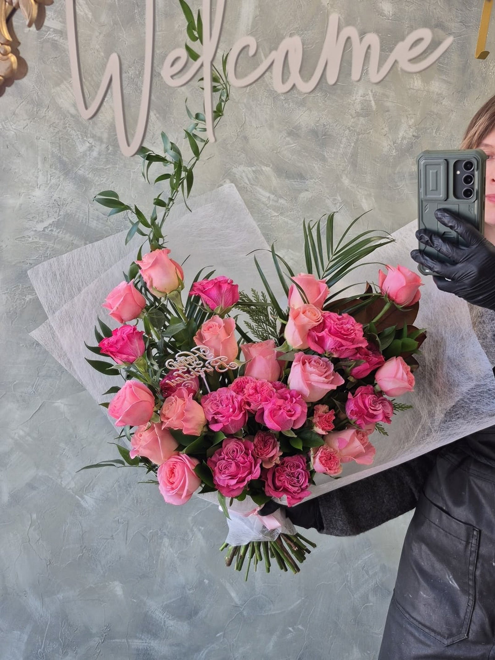 Person holding a bouquet of pink roses 