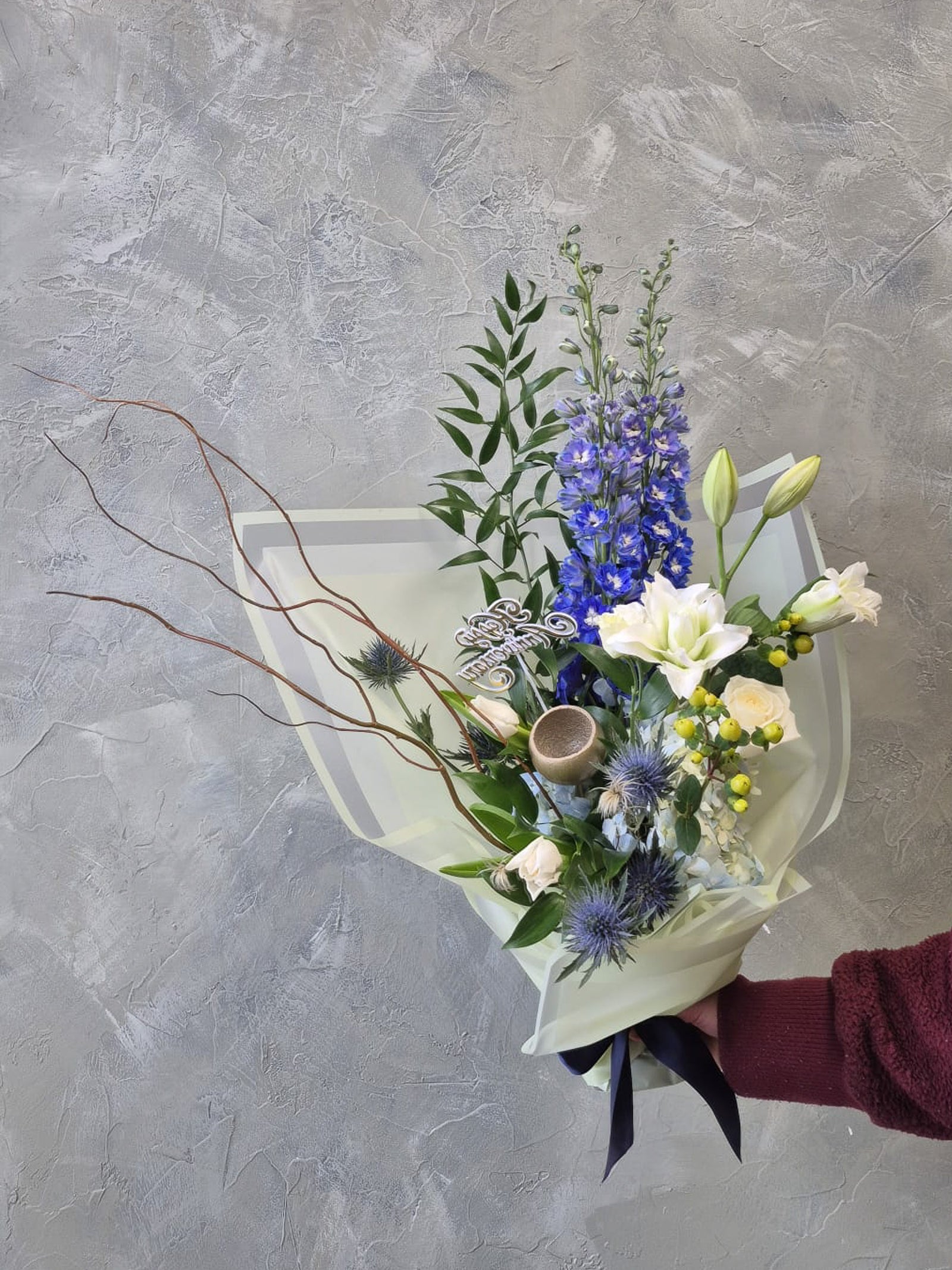 elegant flower bouquet with white and blue flowers; thistle, delphinium, white lilies and branches