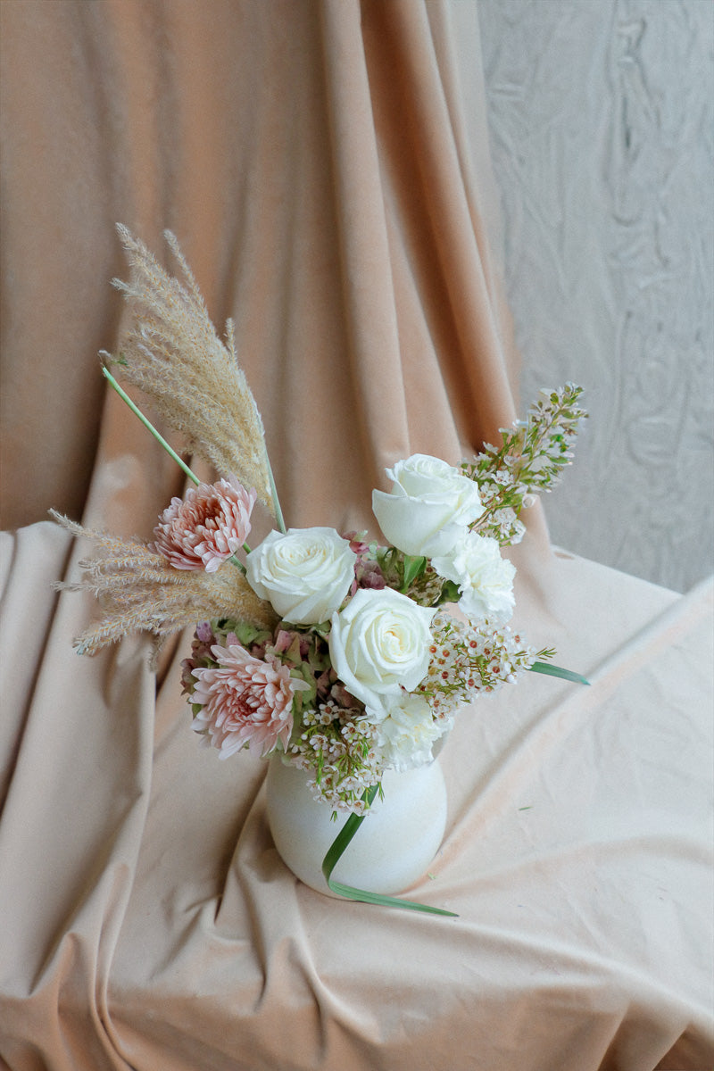 Silk &amp; Earth elegant ivory flower arrangement with white roses and cream florals in light ceramic vase.
