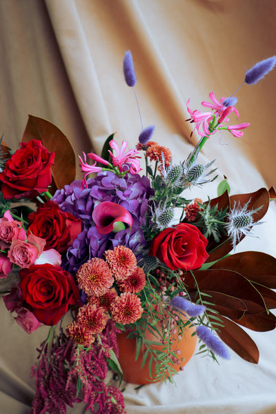 Luxury autumn floral design with magnolia leaves, amaranthus, and cascading hanging elements.