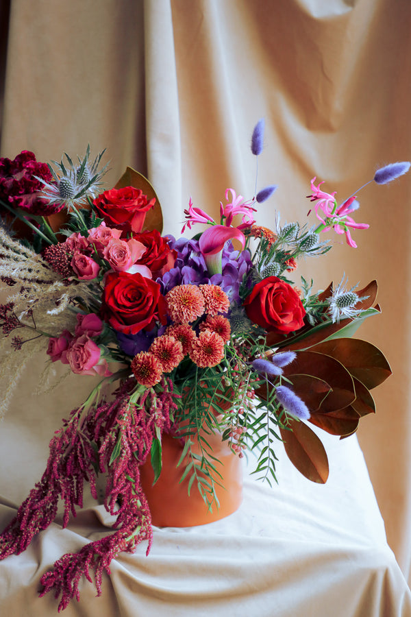 Luxury autumn floral design with magnolia leaves, amaranthus, and cascading hanging elements.