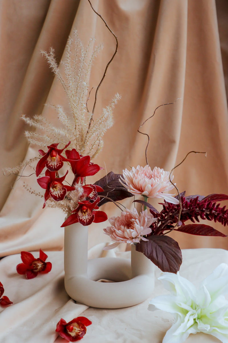 Elegant fall centerpiece in ivory vase, handcrafted with warm seasonal blooms and cozy tones