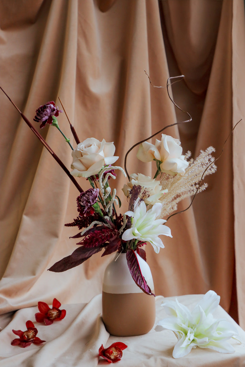 Wine &amp; Shadow fall flower arrangement in double-tone ceramic vase with dark burgundy and ivory blooms.