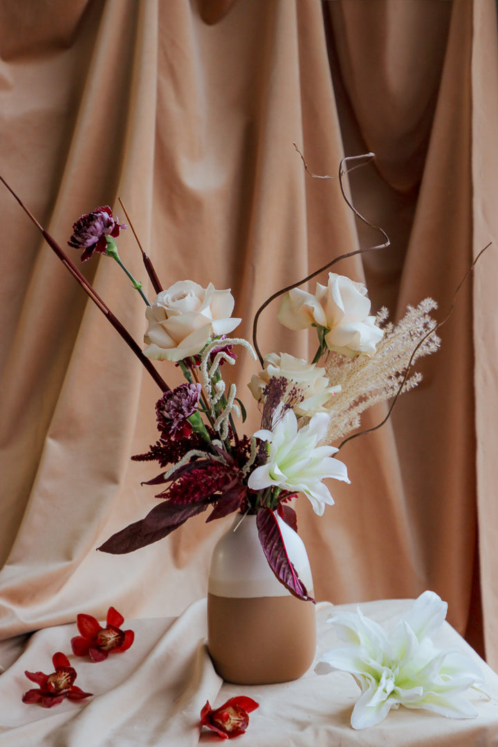 Wine &amp; Shadow fall flower arrangement in double-tone ceramic vase with dark burgundy and ivory blooms.