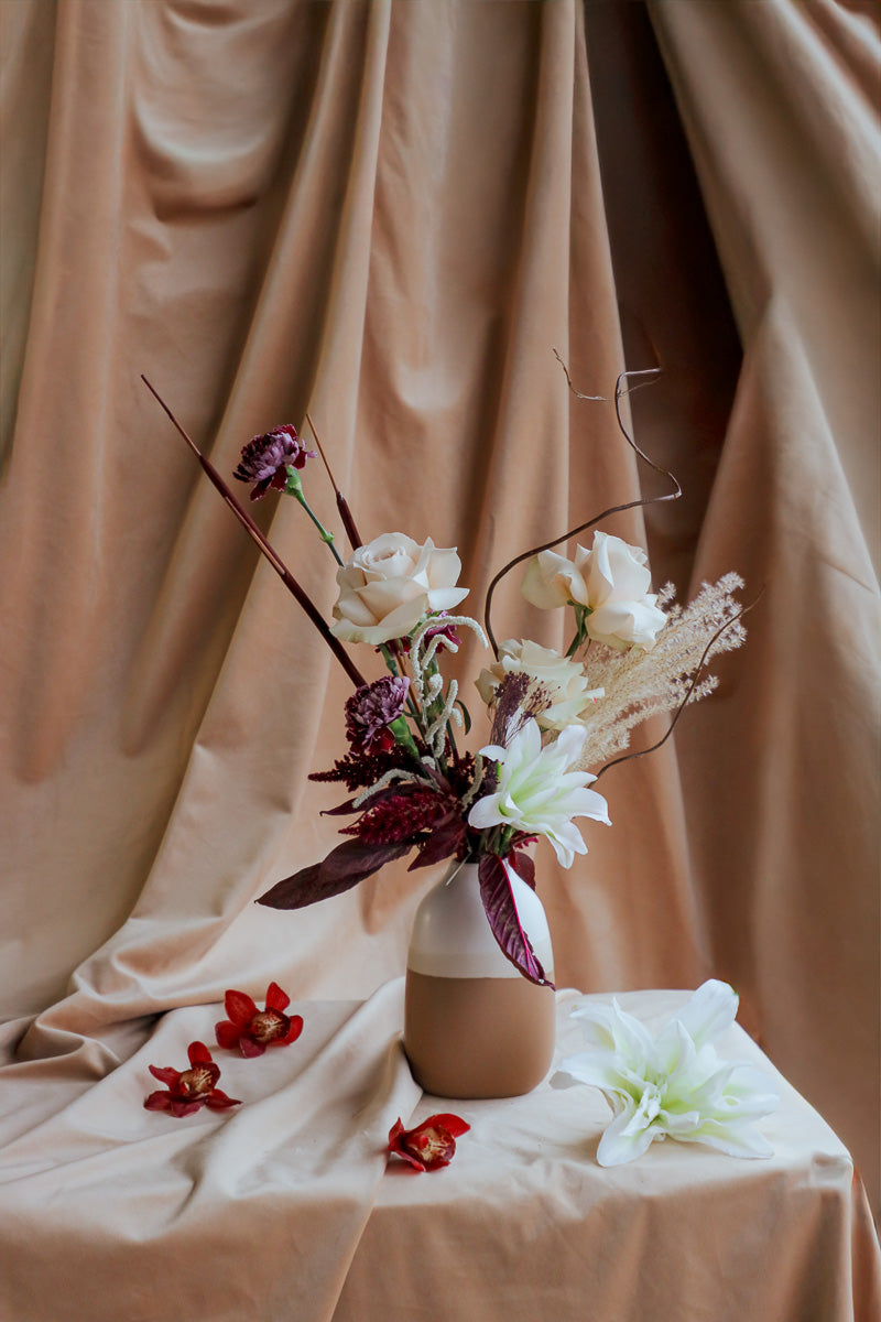 Wine &amp; Shadow fall flower arrangement in double-tone ceramic vase with dark burgundy and ivory blooms.