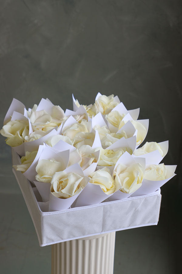 Fresh white rose petals in individual paper cones