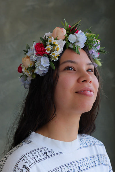 Woman wearing a bright blue and pink floral crown