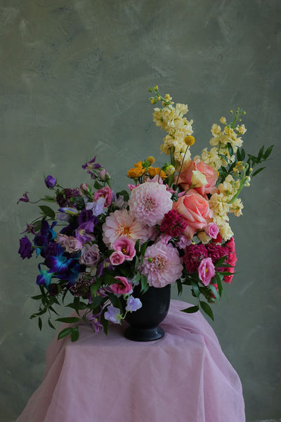 Color Sonata flower arrangement with pink dahlias, orange roses, and purple lisianthus