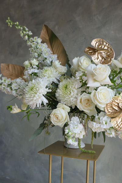 Stylish floral display in cream and gold tones in a white vase