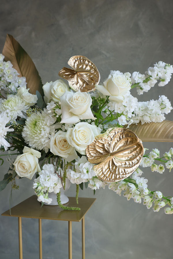Stylish floral display in cream and gold tones in a white vase