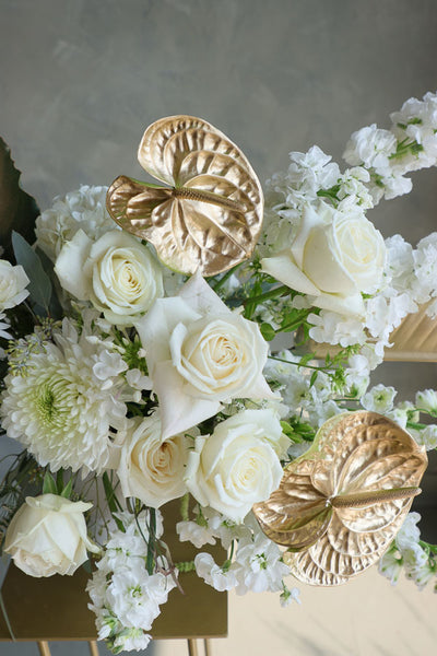 Stylish floral display in cream and gold tones in a white vase