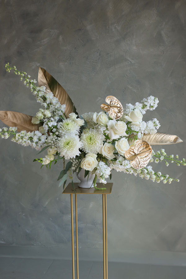 Stylish floral display in cream and gold tones in a white vase