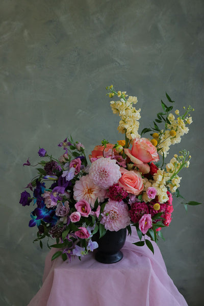 Color Sonata flower arrangement with pink dahlias, orange roses, and purple lisianthus