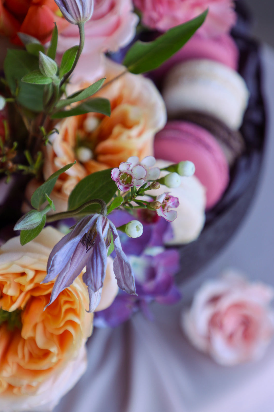close up of clematis in summer-inspired floral and macaron centerpiece