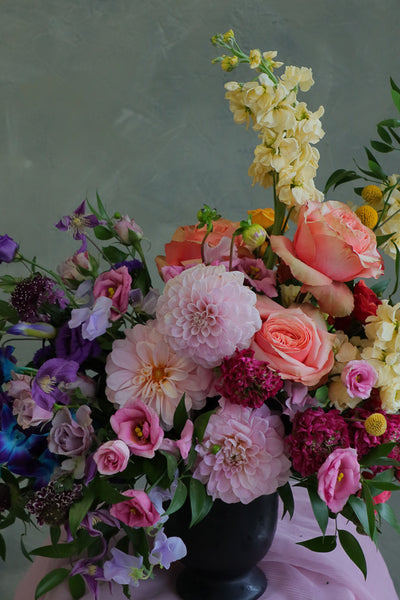 Color Sonata flower arrangement with pink dahlias, orange roses, and purple lisianthus