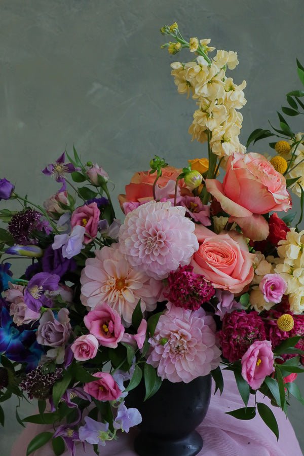 Color Sonata flower arrangement with pink dahlias, orange roses, and purple lisianthus