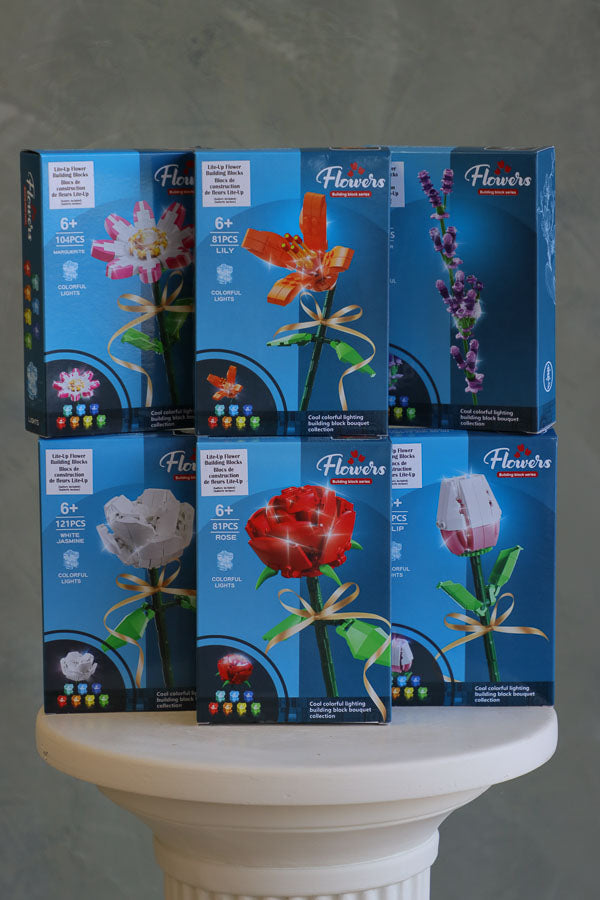 Stacked display of light-up flower building block kits including rose, tulip, lily, carnation, and more – great gift or bouquet add-on