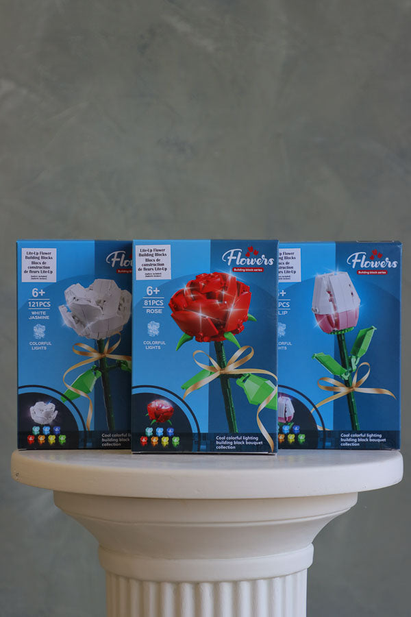 Stacked display of light-up flower building block kits including rose, tulip, white jasmine – great gift or bouquet add-on