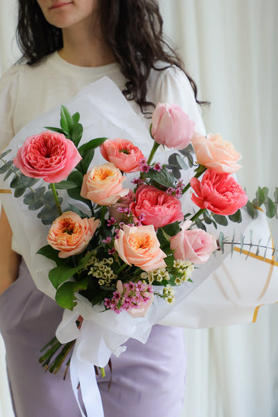 Playful spring bouquet featuring vibrant pink and peach roses, full of joyful, funky vibes perfect for brightening any occasion.