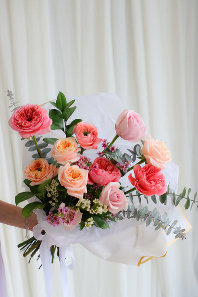 Playful spring bouquet featuring vibrant pink and peach roses, full of joyful, funky vibes perfect for brightening any occasion.