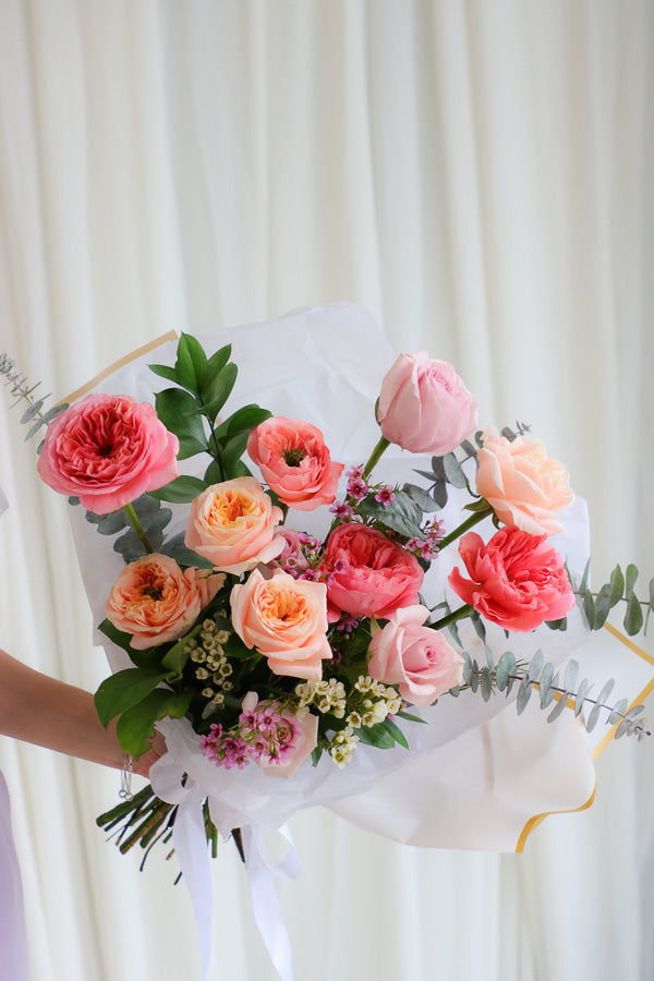 Playful spring bouquet featuring vibrant pink and peach roses, full of joyful, funky vibes perfect for brightening any occasion.