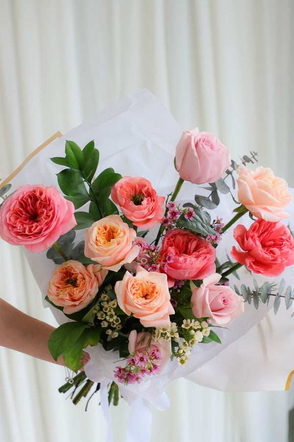 Playful spring bouquet featuring vibrant pink and peach roses, full of joyful, funky vibes perfect for brightening any occasion.