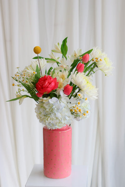 "Good Mood" arrangement featuring vibrant coral peonies, sunny yellow accents, and lush garden blooms in a stylish coral polka-dot vase.