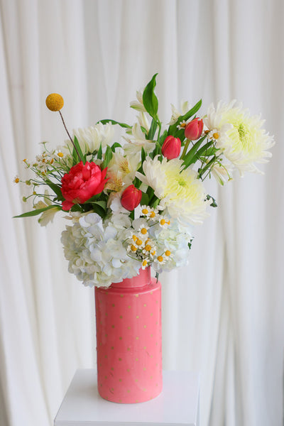 "Good Mood" arrangement featuring vibrant coral peonies, sunny yellow accents, and lush garden blooms in a stylish coral polka-dot vase.