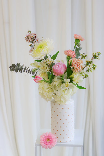 Cheerful "Happy Vibes" arrangement with pink peonies, white hydrangeas, and other gorgeous pink and white flowers in a playful white polka dot vase.