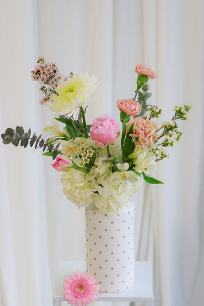 Cheerful "Happy Vibes" arrangement with pink peonies, white hydrangeas, and other gorgeous pink and white flowers in a playful white polka dot vase.