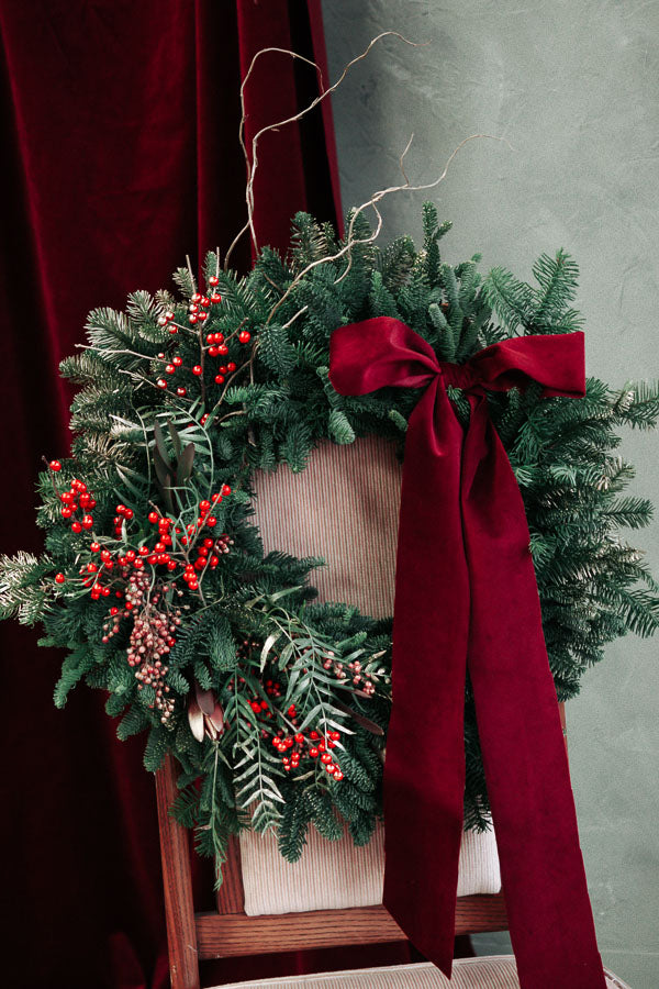 Merry Berry Bow Christmas wreath with red berries, lush greenery, and a red bow by Ottawa florist.