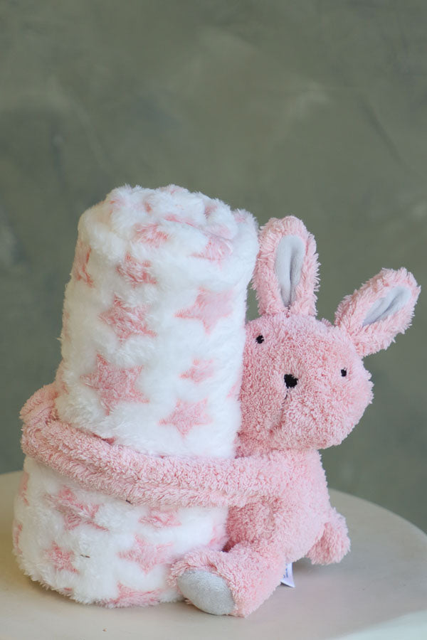 Soft pink bunny plush holding a white fleece blanket with pink stars