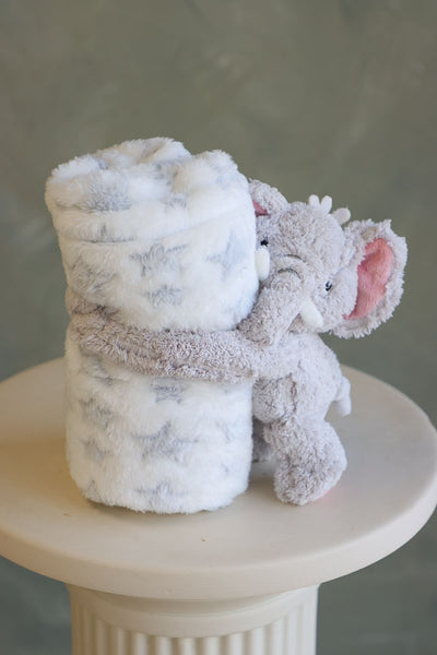 Fluffy gray elephant plush hugging a white fleece blanket with gray stars