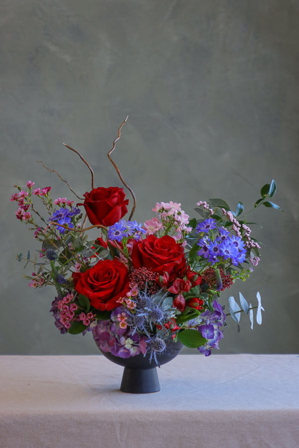 Small wedding and event table centerpiece with red roses and blue flowers