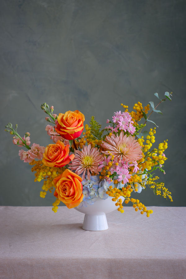 Small wedding and event table centerpiece in yellow, peach and blue colors