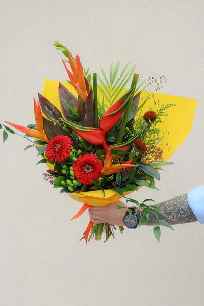 Vibrant Tropical Paradise bouquet with bright gerberas, heliconias, and lush tropical foliage by Ottawa florist.