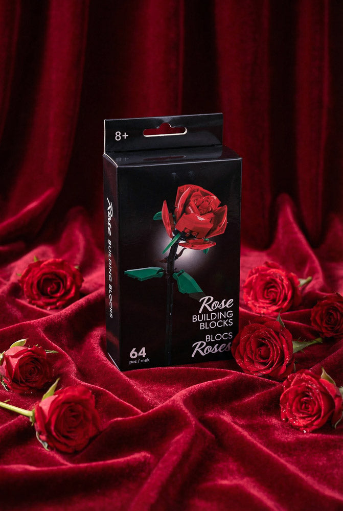 Red rose building block kit displayed in a black box, surrounded by red roses on a velvet background for Valentine’s Day