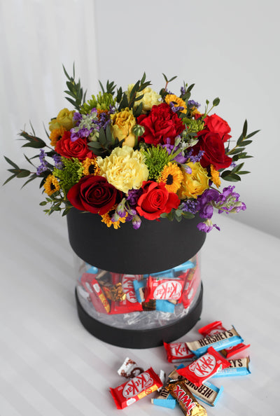 Delicious chocolates and cookies with flowers in a box