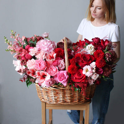  beautiful pink, red and burgundy blooms in a big wooden basket; luxury flower basket