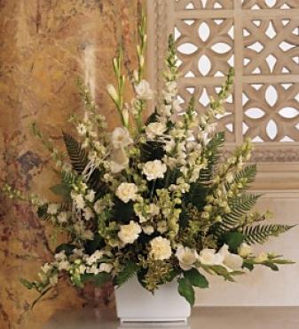white sympathy flowers in a white container